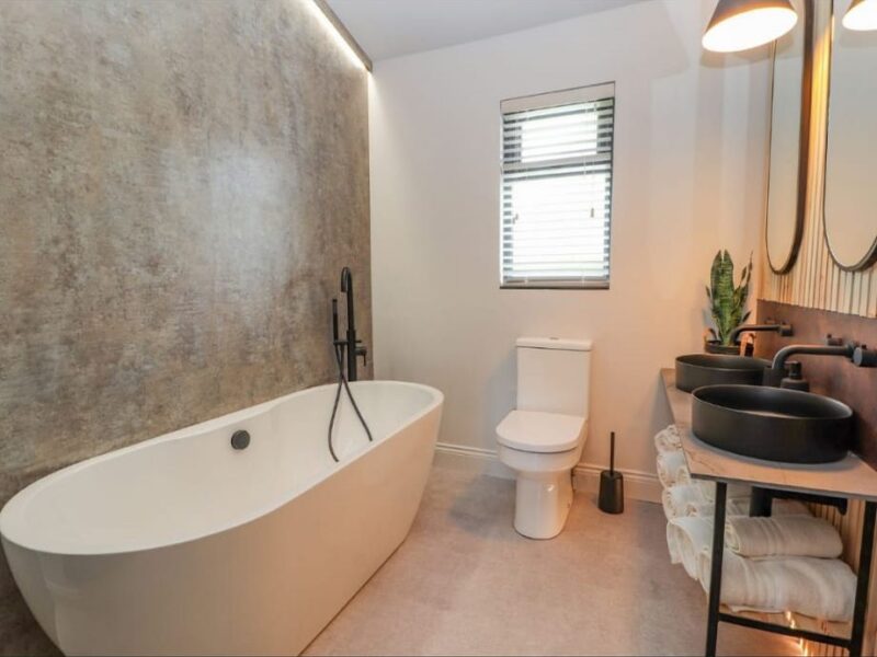 Bathroom with a freestanding bath and stone-effect wall panelling