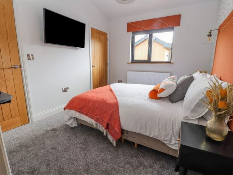 Second double bedroom with a wall-mounted television opposite the bed