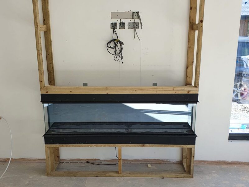 Stud opening framed out for the fireplace, with the hearth and lintel in place