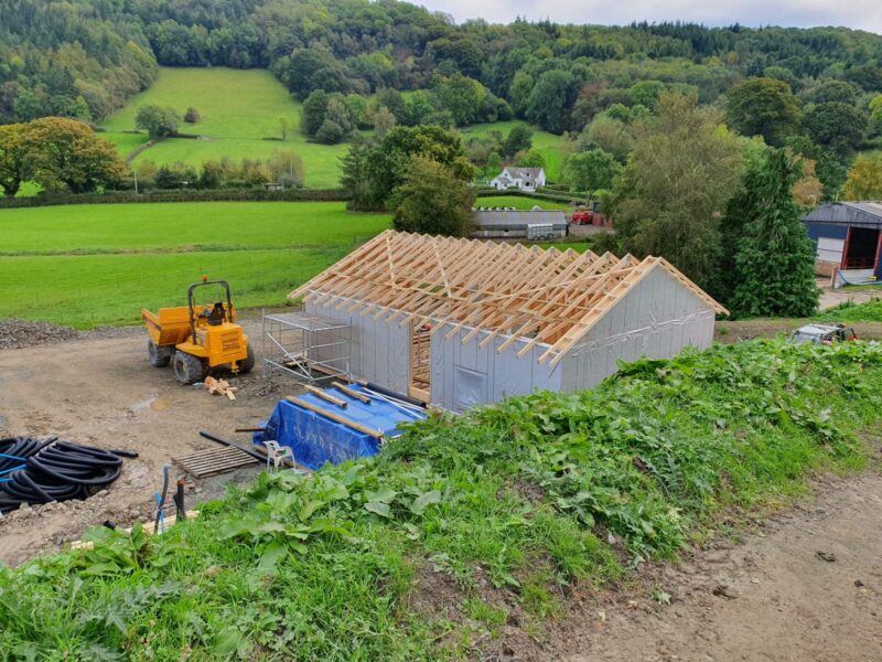 Timber roof frame erected on a lodge, seen across the valley
