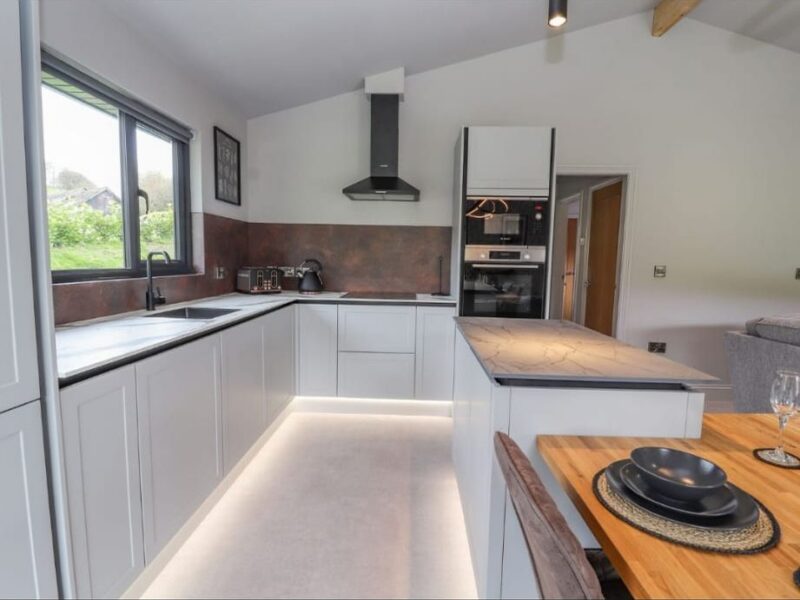 Galley kitchen with a timber worktop, integrated oven and extractor