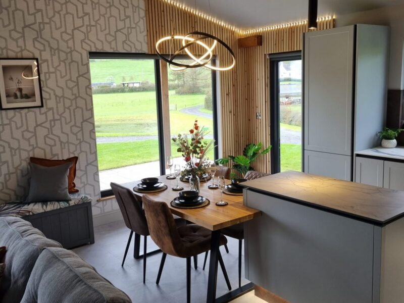 Dining area beside the kitchen island, with a ring pendant light and a patterned feature wall