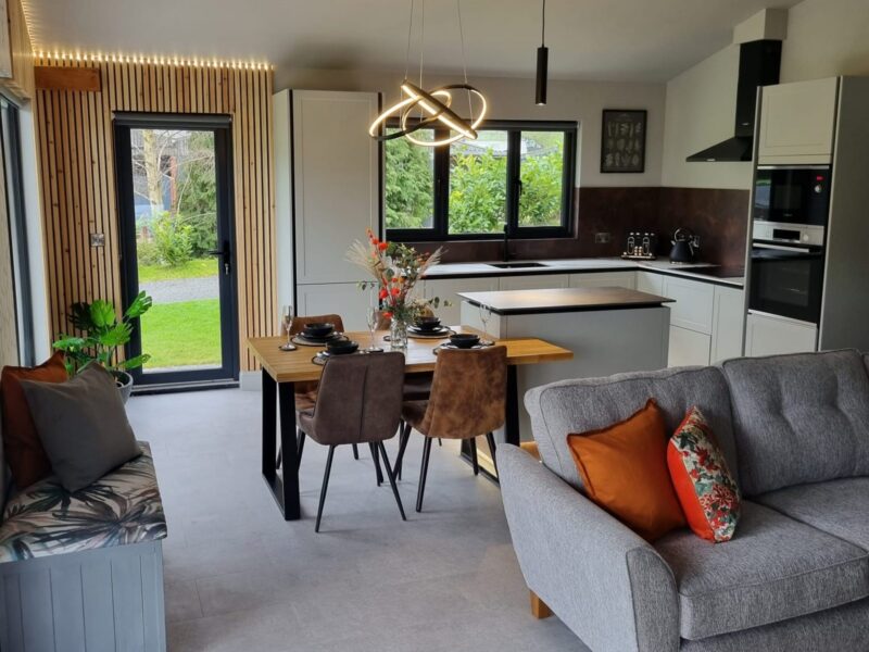 Family area with a dining table, corner sofa and glazing out to the fields