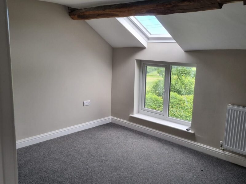 Second bedroom under the eaves with an exposed beam and a roof window
