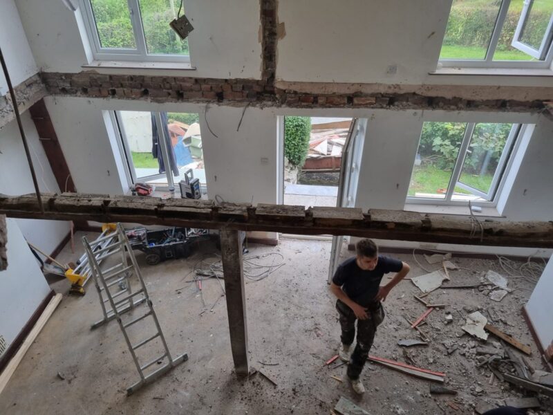 Interior stripped back to the original beams and joists, with debris being cleared